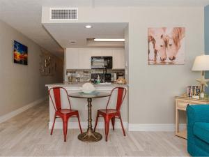 a kitchen with a table and two red chairs at LR 210 - Mustang Isle in Rockport