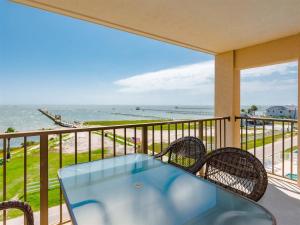 a balcony with a table and chairs and the ocean at LR 403 - Destination Relaxation in Rockport