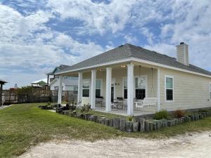 a white house with columns and a porch at Mermaid Bay in Rockport