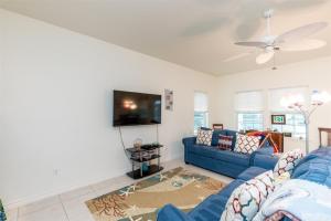 un salon avec un canapé bleu et une télévision dans l'établissement Mermaid Bay, à Rockport