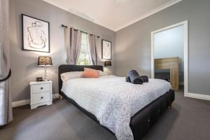 ein Schlafzimmer mit einem großen Bett und einem Fenster in der Unterkunft Tatbern Park Cottage Wallalong in Wallalong