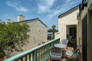 a balcony with chairs and tables on a building at Sea La Vie in Rockport