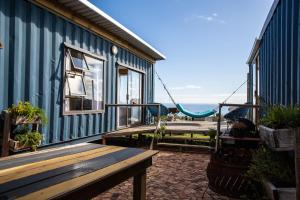 una casa blu con panchina e altalena di Mountain Magic Hoekwil a Wilderness