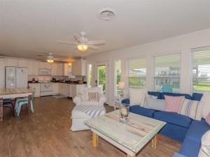 un salon avec un canapé bleu et une table dans l'établissement Tejas Tides, à City-by-the Sea