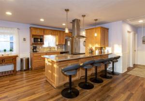 una cucina con armadi in legno e un'isola con sgabelli da bar di Trout Tank a Rockport Altre 10 foto