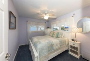 una camera da letto bianca con un letto e uno specchio di Trout Tank a Rockport