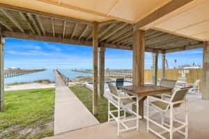 a porch with a table and chairs and a pier at The Cats Meow in Rockport