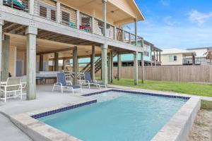 a swimming pool with chairs and a house at The Cats Meow in Rockport