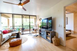 a living room with a couch and a flat screen tv at Sohana Lifestyle Apartment I Leeven's Home I Kona in Kailua-Kona