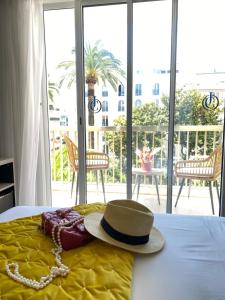 a hat sitting on top of a bed at Hôtel Jardin Croisette in Cannes