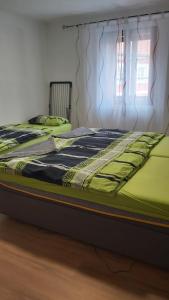 - une chambre avec 2 lits avec des draps verts dans l'établissement Apartment am Schlosspark 3, à Egra