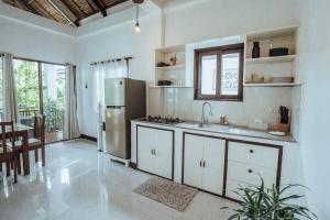 a kitchen with a stainless steel refrigerator and a table at BayayTagoSiargao in General Luna