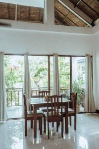 a dining room with a table and chairs and windows at BayayTagoSiargao in General Luna +16 photos