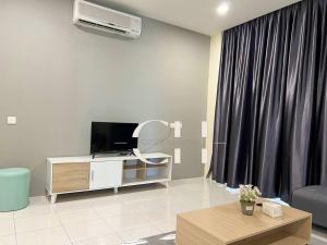 - un salon avec une télévision, un canapé et une table dans l'établissement King bed Kuching Stutong Heights Apartment Nearby Airport, à Kuching