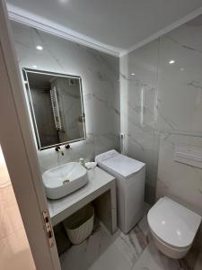 ein weißes Bad mit einem Waschbecken und einem WC in der Unterkunft Modern 1-bedroom apartment in the city center in Thessaloniki