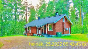a small red house in the middle of a forest at Holiday Home Marina in Tahkovuori