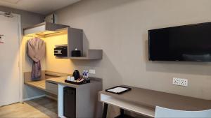 a room with a desk and a tv on a wall at Perdana Hills in Petaling Jaya