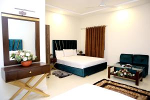 a hotel room with two beds and a mirror at Royalton Inn Hotel - Gulberg in Lahore
