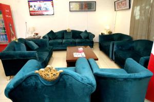 a living room with blue couches and a table at Royalton Inn Hotel - Gulberg in Lahore