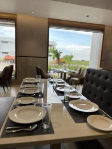 a long table with plates and glasses on it with a view at Kyriad Prestige Ilkal in Ilkal +25 photos