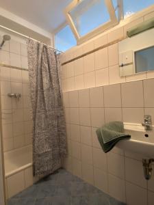 y baño con cortina de ducha y lavamanos. en Ferienwohnung Brötzingen im 4. OG, en Pforzheim