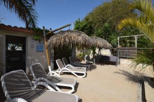 een rij stoelen en parasols op een patio bij Saija Resort in Pozzallo