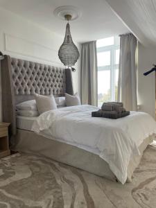a bedroom with a large bed with a large headboard at The Beach Retreat Whitstable in Kent