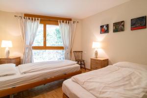 a bedroom with two beds and a window at Edelweiss Slope Side in Flims