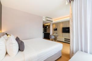 a hotel room with a bed and a tv at Aster Hotel and Residence by At Mind in Pattaya