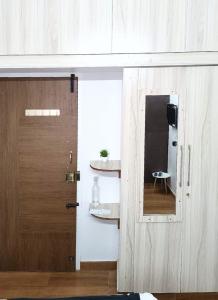 una puerta que da a una habitación con espejo en Meadows Homestay en Madurai