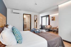 um quarto com uma grande cama branca com almofadas em Hotel Bieze em Borger