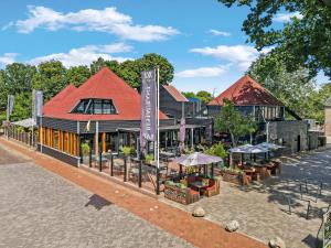 a building with tables and umbrellas on a street at Hotel Bieze in Borger