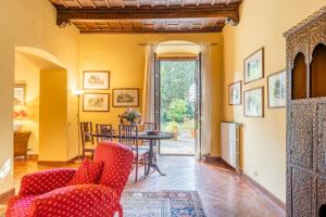 salon z czerwonymi krzesłami i stołem w obiekcie Villa Rita w mieście Vicopisano