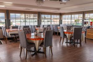 a dining room with tables and chairs and windows at Residence Hotel By Ketenci in İzmir +6 photos