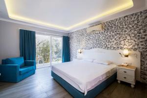 1 dormitorio con 1 cama y 1 silla azul en Hotel Karbel Sun, en Ölüdeniz