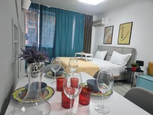 um quarto com uma cama e uma mesa com copos de vinho em Party guesthouse for big groups em Tirana