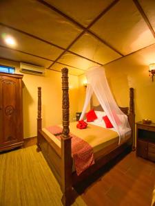 a bedroom with a bed with a canopy at Ombak Dive Resort Perhentian Island in Perhentian Islands