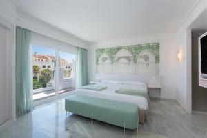 a bedroom with a large bed and a large window at Iberostar Selection Marbella Coral Beach in Marbella