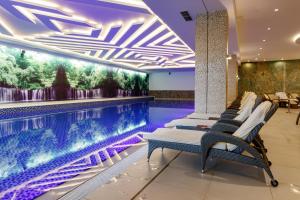 a hotel lobby with a swimming pool and lounge chairs at Hotel Buket Zlatibor in Zlatibor