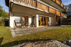 a patio with a table and chairs in front of a house at Edelweiss Slope Side in Flims