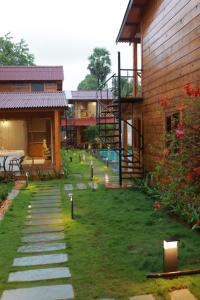 a backyard of a house with a pathway and a house at Wooden ECR Sea Resort in Puducherry