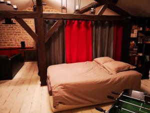 - une chambre avec un lit à baldaquin et des rideaux rouges dans l'établissement Maison familiale de l Abbaye, à Clairvaux