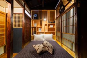 Bamba Hotel Tokyo-Private Townhouse- في طوكيو: غرفة نوم بسرير في غرفة بجدران خشبية