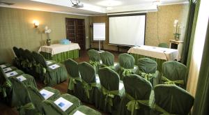 einen Konferenzraum mit grünen Stühlen und einem Bildschirm in der Unterkunft Avrora Business Hotel in Kursk