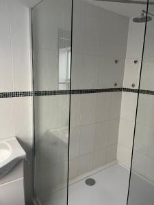 La salle de bains est pourvue d'une douche avec une porte en verre. dans l'établissement Shakers Inn, à Harwich