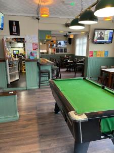a pool table in a restaurant with a bar at Shakers Inn in Harwich