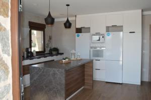 cocina con electrodomésticos blancos y encimera en Casa Rural Finca Bella, en San Clemente