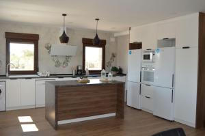 una cocina con electrodomésticos blancos y una isla de madera en Casa Rural Finca Bella, en San Clemente