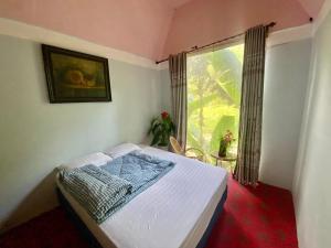 a bedroom with a bed and a large window at Homestay Điện Biên- Thung Lũng Hoa Hồng in Diện Biên Phủ