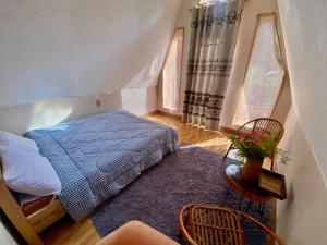 a bedroom with a bed with a blue blanket and two windows at Homestay Điện Biên- Thung Lũng Hoa Hồng in Diện Biên Phủ